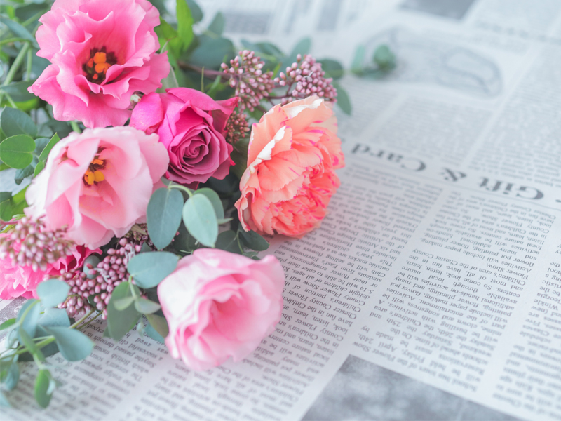 ピンクの花束と英字新聞